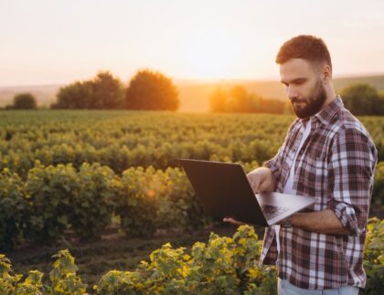 hombre con ordenador en campo de cultivo
